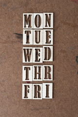 days of the workweek (mon to fri) in wooden stencil font on grungy work board - obrazy, fototapety, plakaty