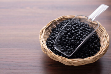 black bean in basket on wood table and plastic spoon. Protein nutrition ingredient for vegetarian.