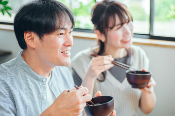 温かい汁を飲む男女（味噌汁、スープ）
