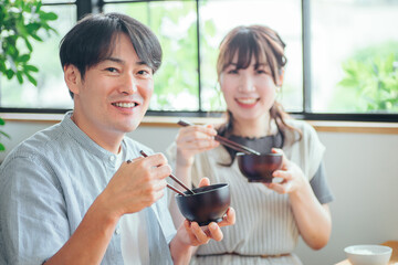 温かい汁を飲む男女（味噌汁、スープ）
