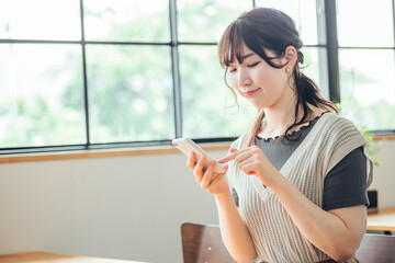 カフェでスマホを使う女性（見る）
