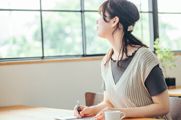 おしゃれ空間で勉強する女性（笑顔）
