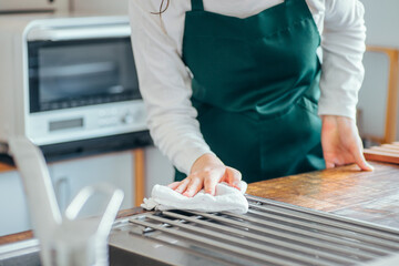 ハウスクリーニングする男女（台拭き・水道）
