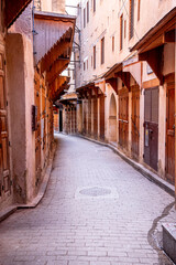 Narrow old street of cobblestone with closed door of houses in residential building