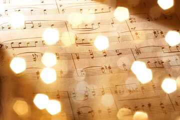 Old sheet with Christmas music notes as background bokeh