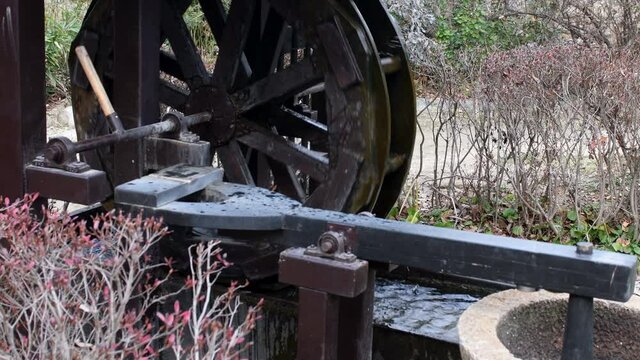 Old fashioned waterwheel mill in park.