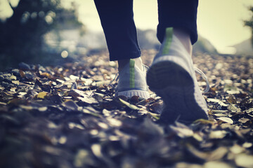 スニーカーを履いて歩く女性の足元