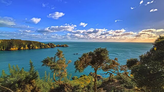 Sunset timelapse of clouds blowing over the sea by the Gurnsey Island in the English Channel off the coast of Normandy, part of the Bailiwick of Guernsey.
