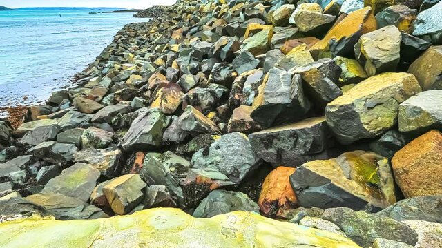 rising sea tide advancing over the rocky breakwater at daytime. Hyperlapse shot