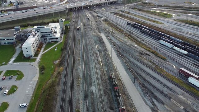 Aerial view following diesel locomotive above MacMillan railroad yard tracks Vaughan, Canada, tilt down