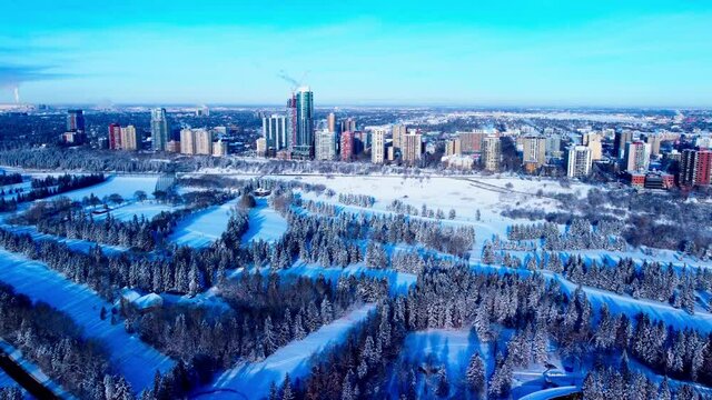 Winter Aerial flight forward over cross country skiing park towards the most luxurious residential real estate in the Edmonton Westside from 116th St NW to 125th St NW at the rivers edge park G1-2