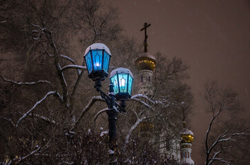 A pole with burning lamps in the evening outside in winter.