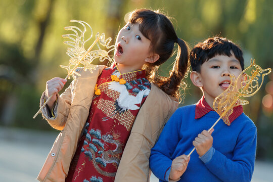 Happy girl and boy to eat traditional candy to celebrate the New Year