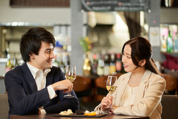 レストランで乾杯をするアジア人のカップル