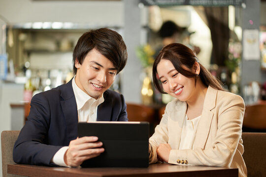 タブレットのメニューで注文するアジア人のカップル