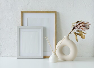 Frame mockup , modern ceramic vases with dry flowers on white background.Neutral color. Photo frame, poster template on white wall background. Scandinavian interior. Copy space.