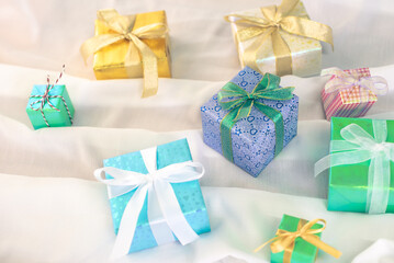 Beautiful new year present boxes. Colored Presents for Birthdays. Boxes with gifts tied with ribbon and bows background. craft paper present box. Christmas tree toys and lights. Christmas presents.