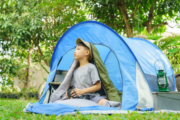 happy boy in camping tent.boy holding binoculars in adventure time.