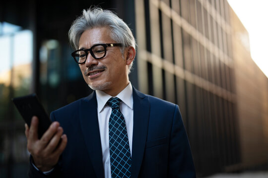 Senior Businessman Outdoors. Middle-aged Businessman Using The Phone.