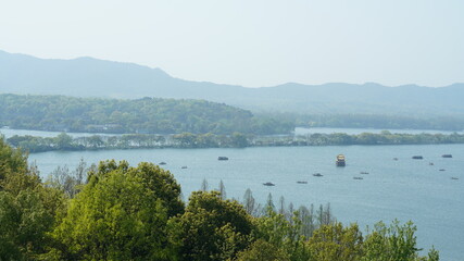 The beautiful lake landscapes in the Hangzhou city of the China in spring with the peaceful lake and fresh green mountains