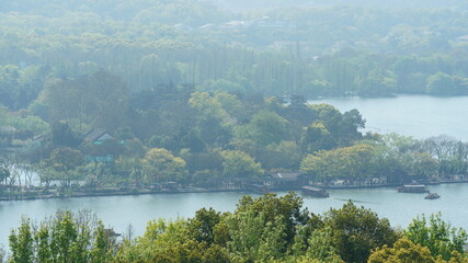 The beautiful lake landscapes in the Hangzhou city of the China in spring with the peaceful lake and fresh green mountains