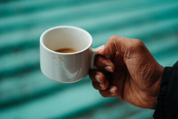 Closeup shot of hand of an Indian man holding tea cup