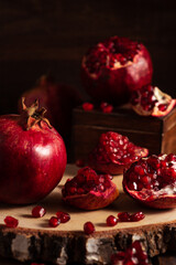 Red ripe pomegranates on a wooden background. The cut fruits of the pomegranate tree.