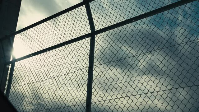 ビルの屋上のフェンス越しに流れる雲　タイムラプス