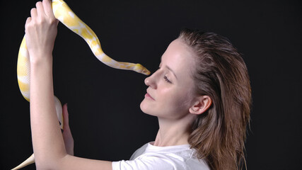 Photo of albino python kissing blond woman - obrazy, fototapety, plakaty