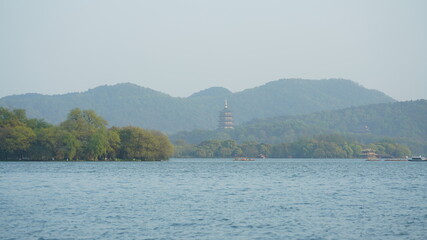 The beautiful lake landscapes in the Hangzhou city of the China in spring with one old temple tower located on the shore