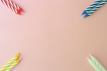 Colourful candles isolated in the green rope on pink background. Birthday,Christmas and special greetings concept. © Hari