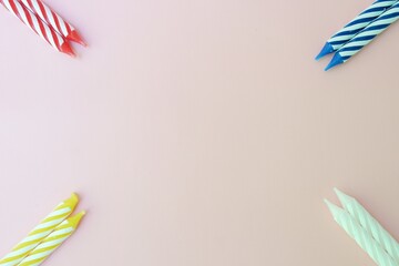 Colourful candles isolated in the green rope on pink background. Birthday,Christmas and special greetings concept. © Hari
