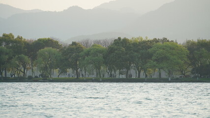 The beautiful lake landscapes in the Hangzhou city of the China in spring with the peaceful lake and fresh green mountains