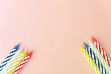 Colourful candles isolated in the green rope on pink background. Birthday,Christmas and special greetings concept. © Hari
