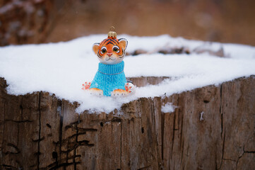 Christmas toy of a tiger cub on a stump damaged by insects. Wood texture. Selective focus.