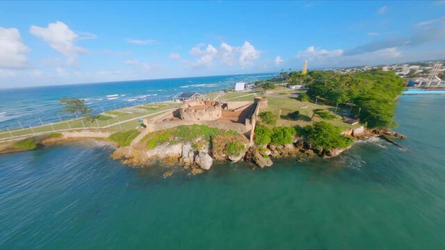 Fpv drone flight over San Felipe Fortress and harbor with boats in Puerto Plata during sunny day