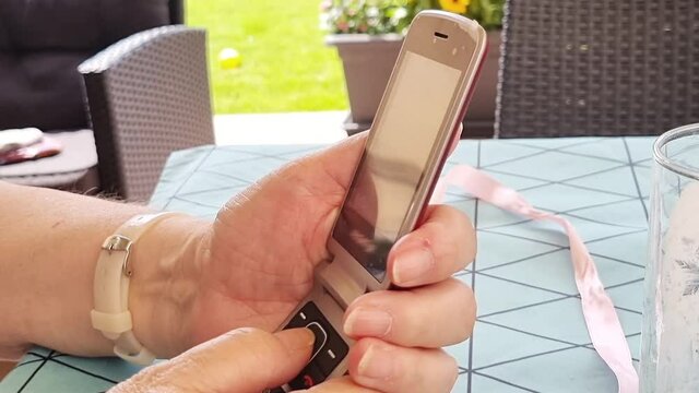 Elderly grandma using old flipphone to send sms
