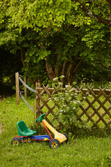 Kettcar auf Rasen vor Gartenzaun