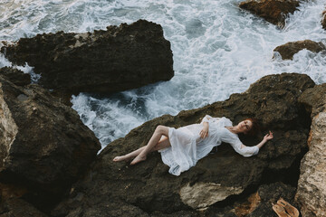 Barefoot woman in white wedding dress on sea shore wet hair vacation concept