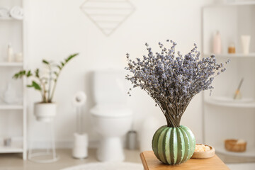 Vase with beautiful lavender flowers in bathroom