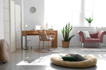 Interior of light living room with pink armchair and modern workplace