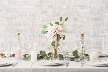 Beautiful table setting for wedding near beige brick wall