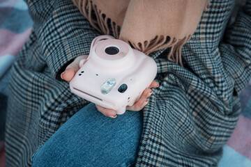 Woman hands holding a pink instax camera