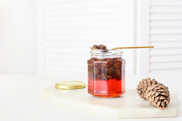 Jar of tasty pine cone jam on light table