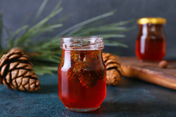 Jar of tasty pine cone jam on dark background, closeup