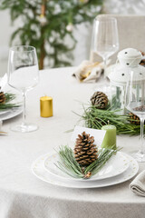 Beautiful table setting with pine cones, blank card and fir branches indoors