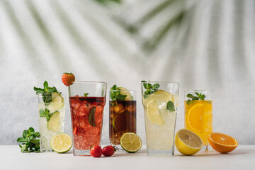 Set of various summer refreshing lemonades. Lime, strawberry, cuba libre, lemon, orange drinks with ice on light background