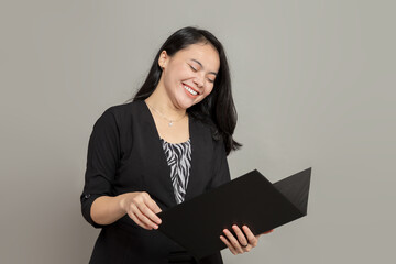 Young business woman laughing while holding folder