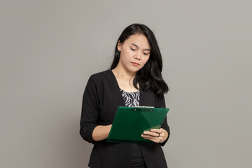 Fototapeta premium Business woman writing on clipboard with flat facial expression
