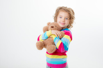 a little cute girl holding a teddy bear isolated on a white background